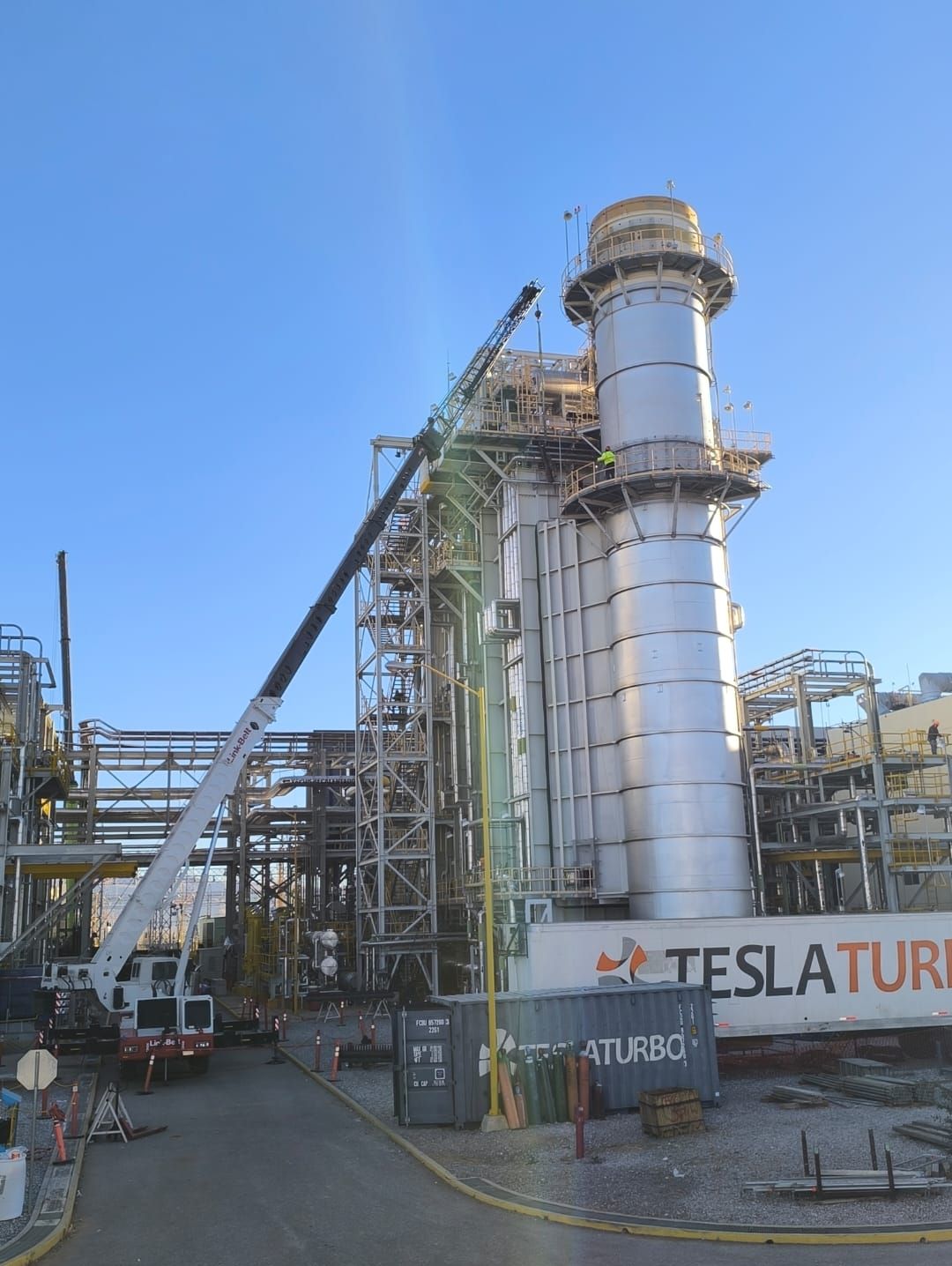 Grúa en maniobra de izaje junto a la chimenea de un HRSG